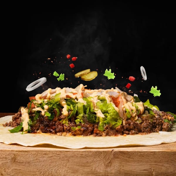 Munchies burger wrap with ground beef, lettuce, onions, and sauce, with ingredients floating above.